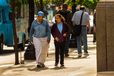 CHICAGO - May 29, 2019: Two women walking and talking on East Jackson Boulevard in Chicago.のeditorial素材