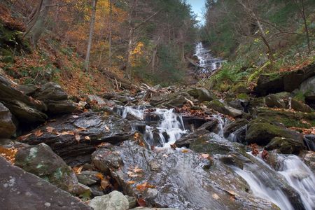 A watefall tumbles over ancient granite in Autumnの写真素材