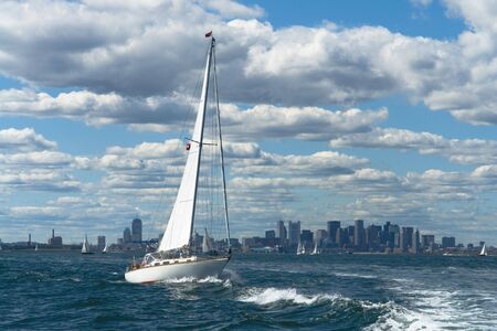 A sailboat manages through wavesの写真素材