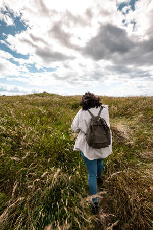 Girl walking in a natural path at the coastの写真素材