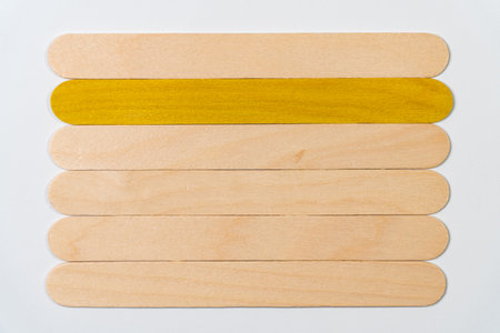 Six wooden sticks, one with color on a white background.の写真素材