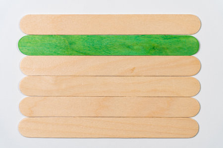 Six wooden sticks, one with color on a white background.の写真素材