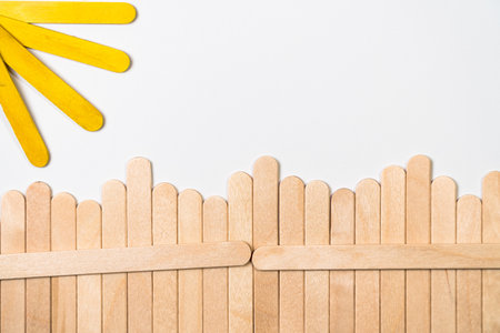 Wooden sticks fence with sunbeams on white background.の写真素材