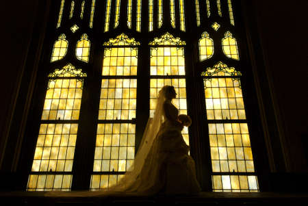 Bride silhouette against stained glassの写真素材