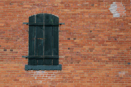 Background - old brick wall with green shutterの写真素材