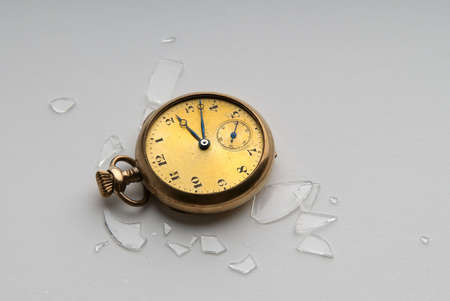 Antique gold watch with shattered crystalの写真素材