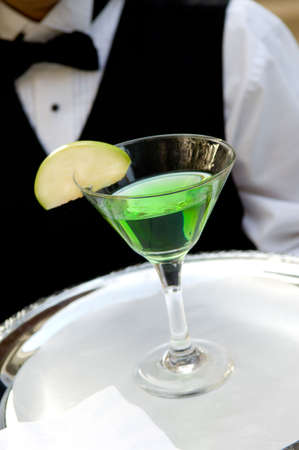 image of an apple martini drink with an apple garnish being servedの写真素材