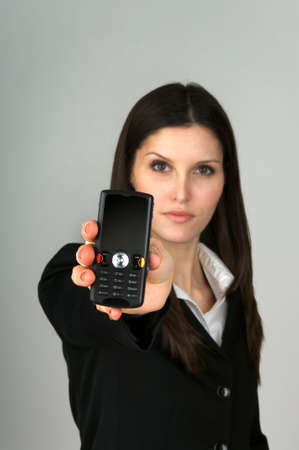 Image of a business woman holding a black cell phoneの写真素材