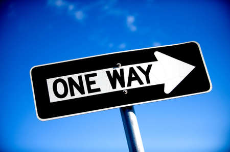 Image of a One Way Sign with blue skyの写真素材