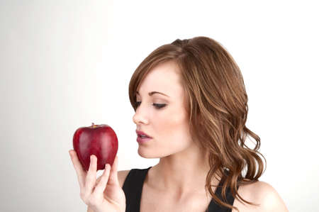 Image of a beautiful gilr holding an apple and examining itの写真素材