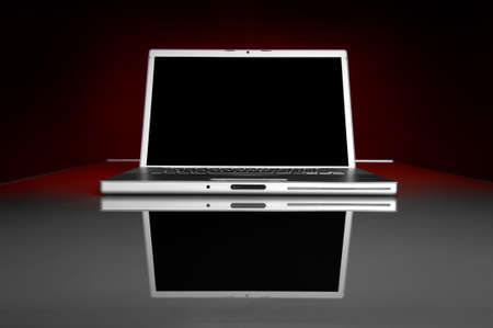 Image of a dark screen laptop on a glass table with reflectionの写真素材