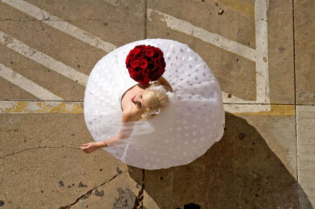 Image of a bride twirling her dress in a parking lotの写真素材
