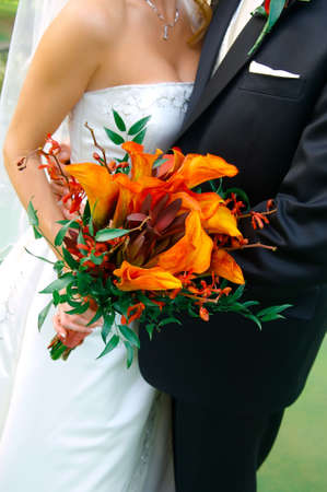 Image of a colorful bouquet being held by a bride and groomの写真素材