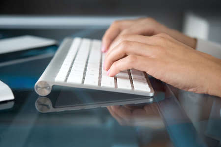 A woman hands typing on a computer keyboardの写真素材