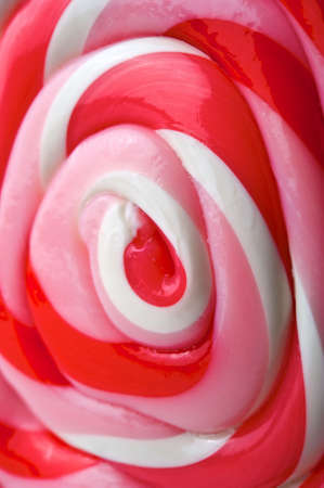 Close up image of a red, pink, and white swirly lollipopの写真素材
