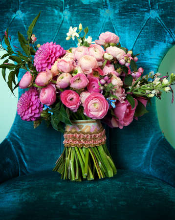 Image of a pink toned bridal bouquet sitting on a chairの写真素材