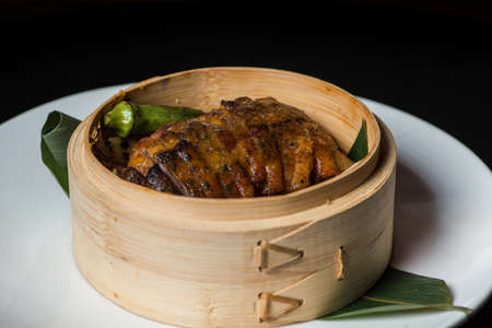 Steamed duck with okra in bamboo bowlの写真素材