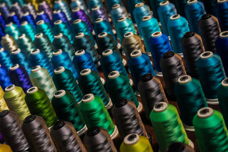 Multicolored threads on spindles in rowsの写真素材