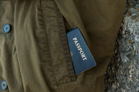 Image of a passport partly exposed in coat pocketの写真素材