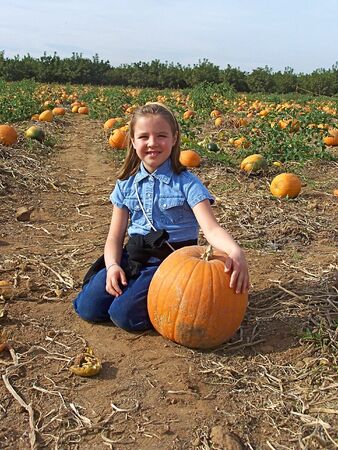 Young girl with pumpkin at the farm