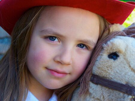 Girl playing with toy horseの写真素材