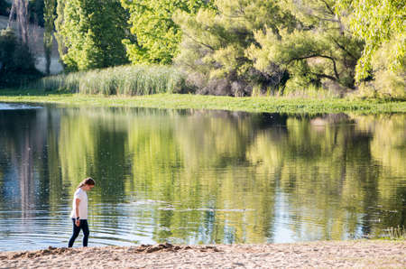 Girl Walking on Lake Shore in The Day Light.の写真素材