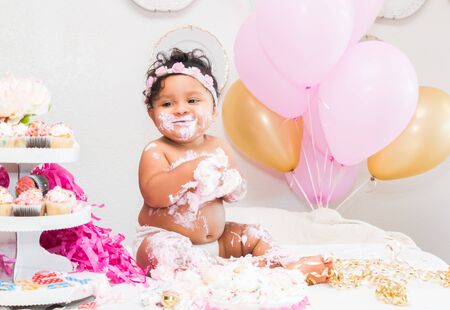 Cute Baby Girl Sitting With Cake and Balloonsの写真素材