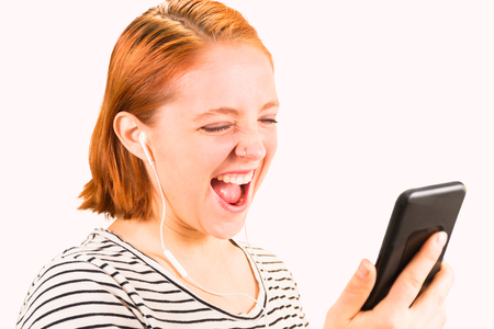 Beautiful Young Redhead Girl Looking at Cellphoneの写真素材