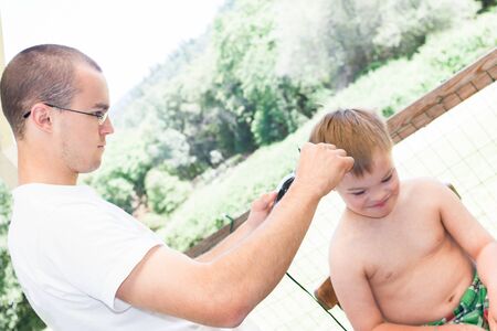 Cute Little Boy With Downs Syndrome Geting His Haircutの写真素材