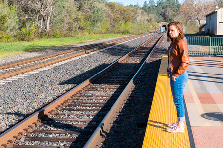 Cute Young Girl Standing Near Train Railsの写真素材