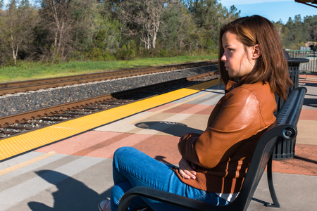 Cute Young Girl Sitting Near Train Railsの写真素材