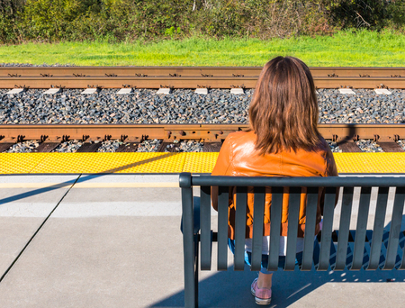 Cute Young Girl Sitting Near Train Railsの写真素材