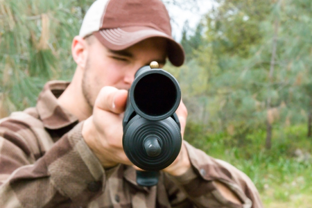Young Man Hunting With Shotgun, Focus is on the Foreground.