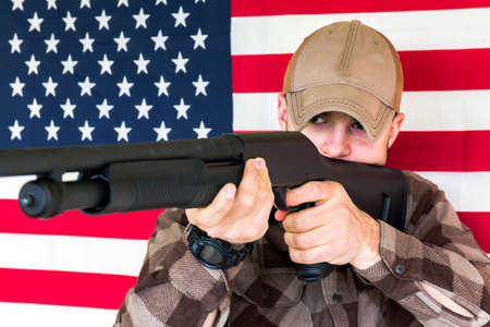 Young Man With Shotgun on American Flag Background
