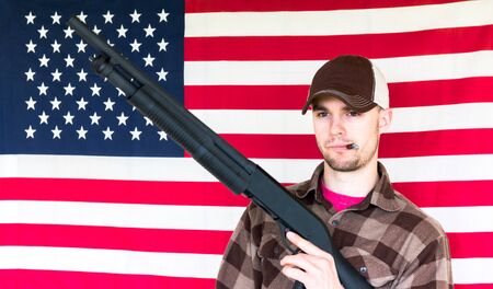 Young Man With Shotgun on American Flag Backgroundの写真素材