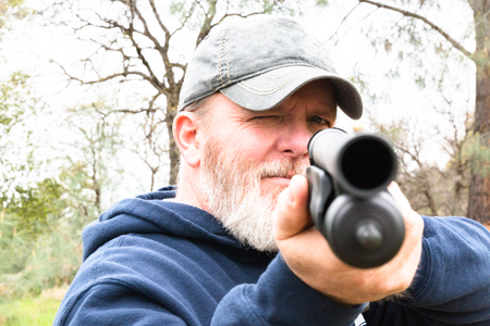 Man With White Beard Aiming Shotgun