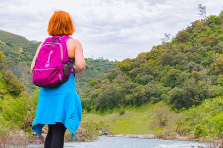 Young Girl Standing on Rocks Near Fast Riverの写真素材