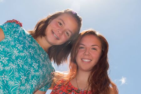 Two Girls With Blue Sky and Bright Sunlight in the Backgroundの写真素材