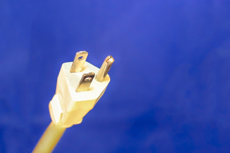 White Electrical Plug and Cord Isolated on Blue Backgroundの写真素材