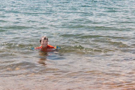 Little Boy With Downs Syndrome Playing in the Water at the Beachの写真素材