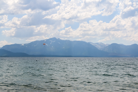 Parasailing on the Lake With Bright Sunlight and Mountains in the Backgroundの写真素材