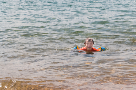 Little Boy With Downs Syndrome Playing in the Water at the Beachの写真素材