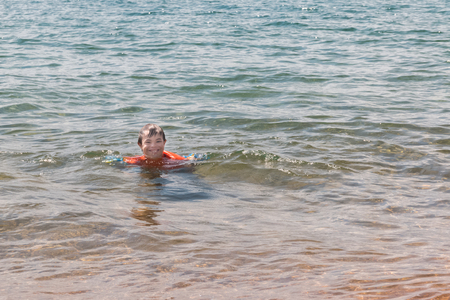 Little Boy With Downs Syndrome Playing in the Water at the Beachの写真素材