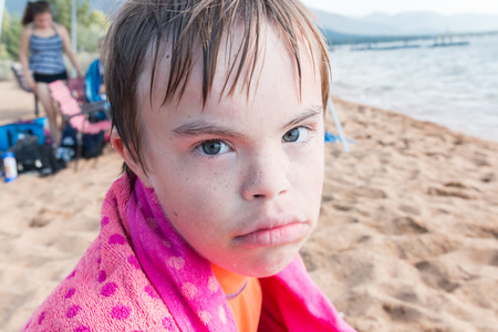 Beautiful Boy With Downs Syndrome Sitting at the Beachの写真素材