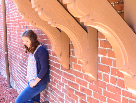 Young Girl Leaning Against Old Red Brick Wallの写真素材