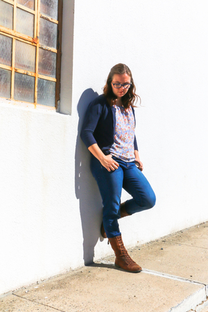 Beauiful Young Girl Leaning Against White Wallの写真素材