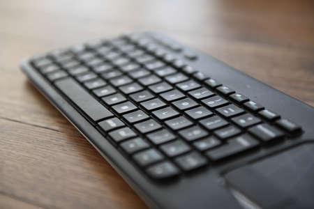 qwerty keyboard sitting on wooden deskの写真素材
