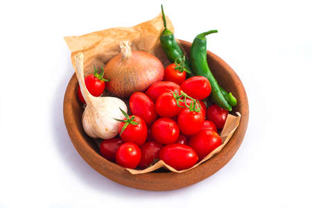 Vegetables in a clay plate isolated on whiteの写真素材