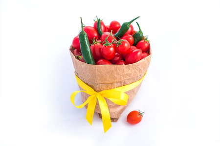 Tomatoes and chili peppers in paper bagisolated on whiteの写真素材