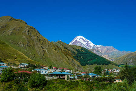 Mountain Kazbek and village Stepantsminda in Georgiaの写真素材